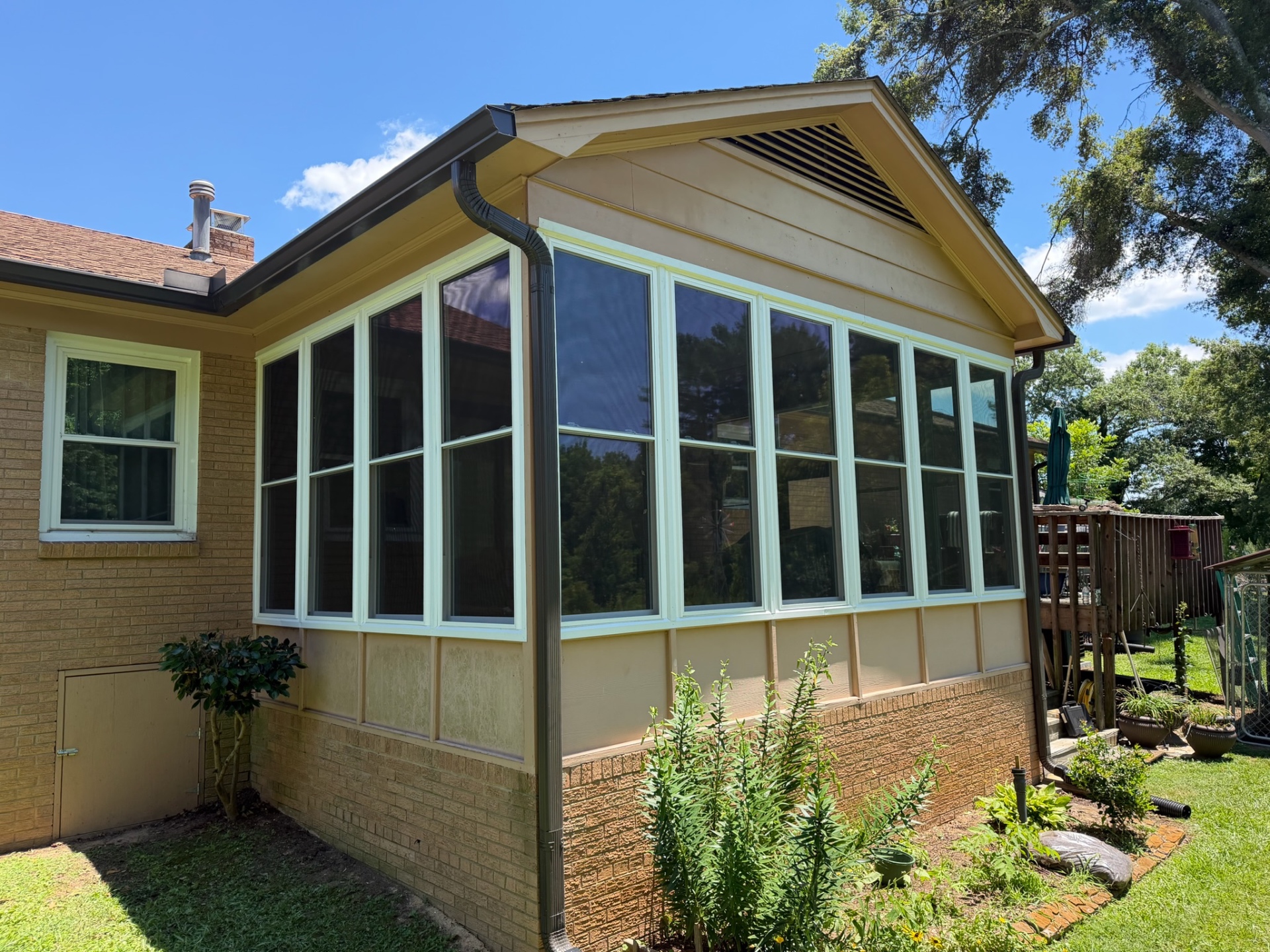 Custom sunroom addition with wall-to-wall windows and gabled roof