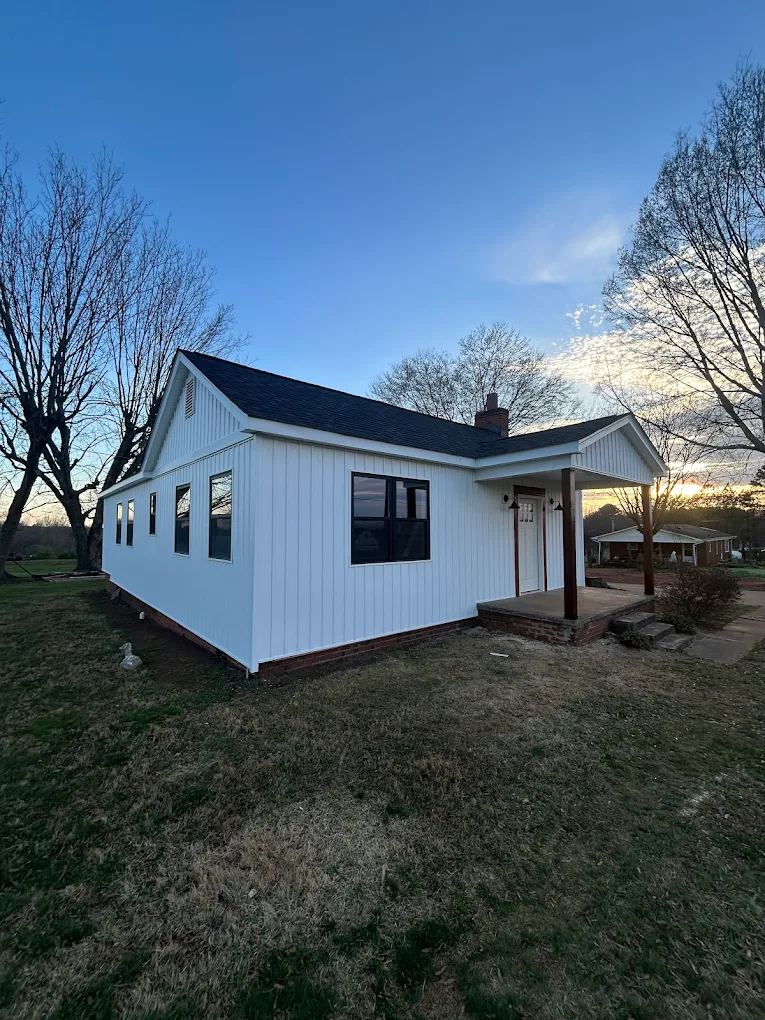 Full exterior renovation with white siding and new windows